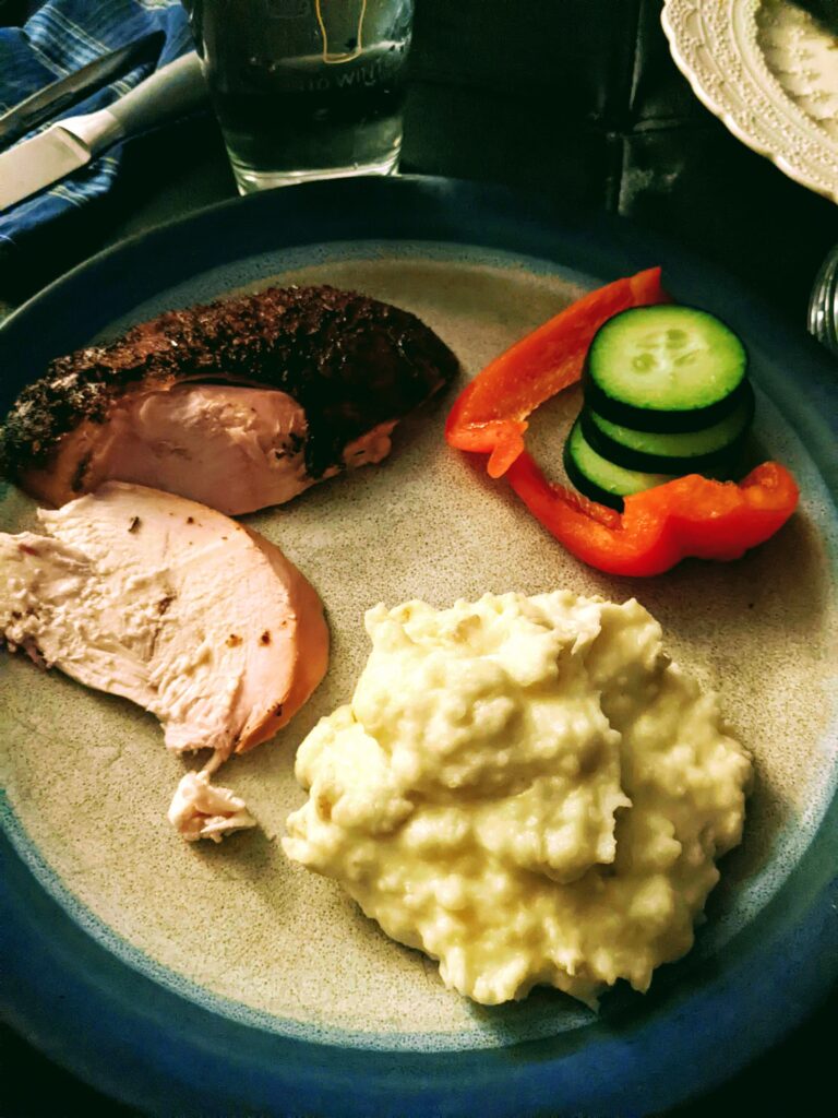  A plate of smoked chicken, sliced pepper, sliced cucumber, and mashed potatoes
