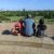 A man and his 2 daughters sit atop Primrose Hill, viewing the London skyline.